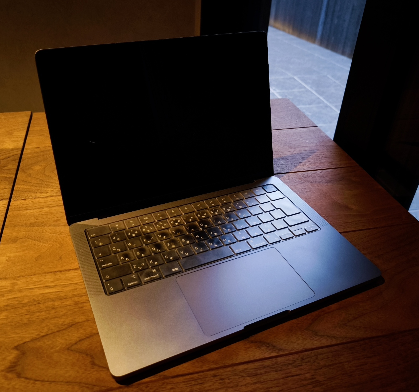 木のテーブルの上で開かれたMacBook